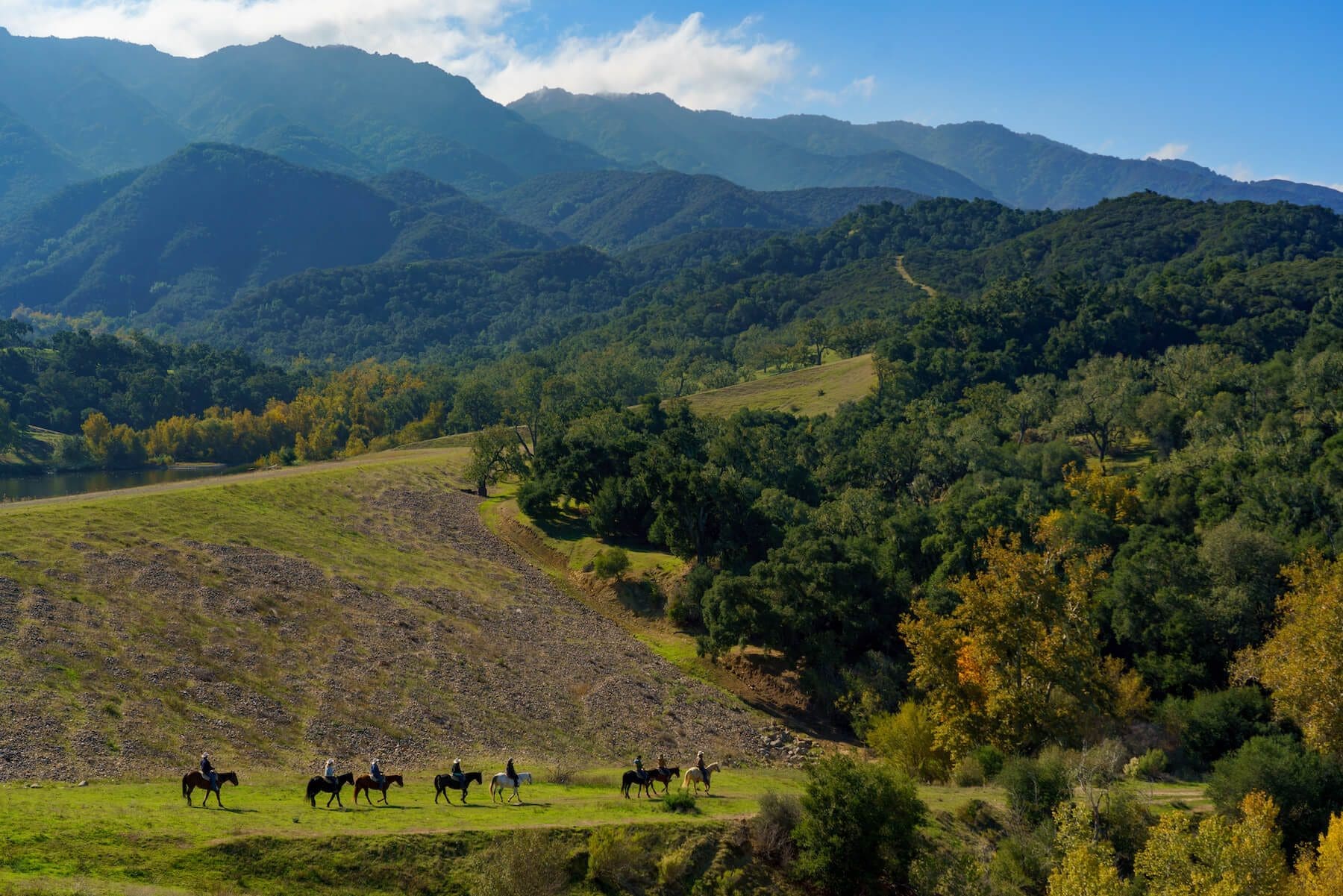 landscape view of the ranch and people riding horses