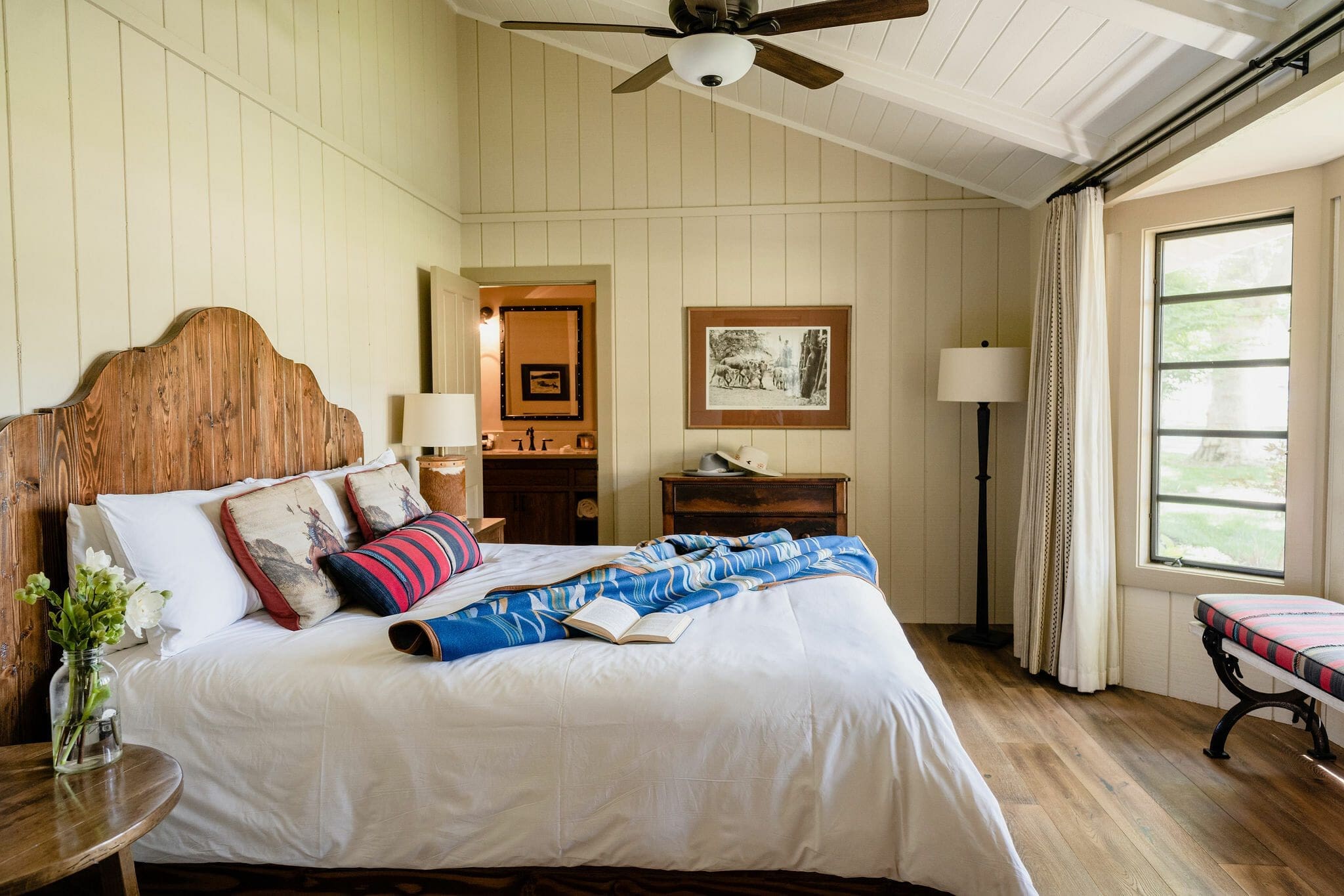 queen bed with side tables and door to bathroom inside the Sycamore house