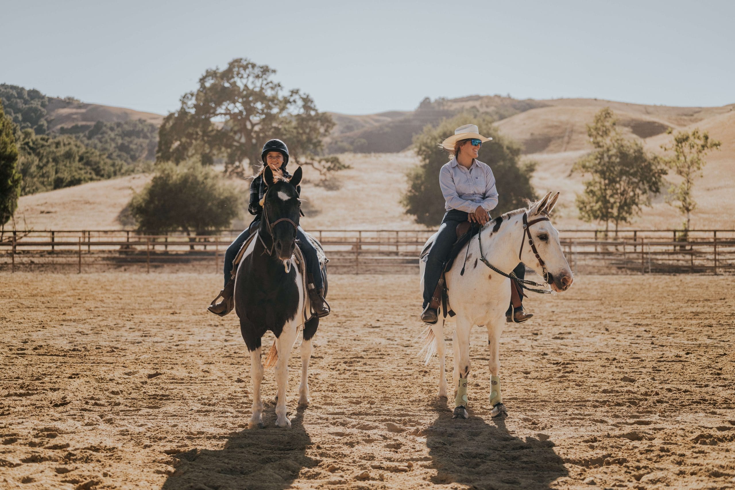 young person and adult riding on horses