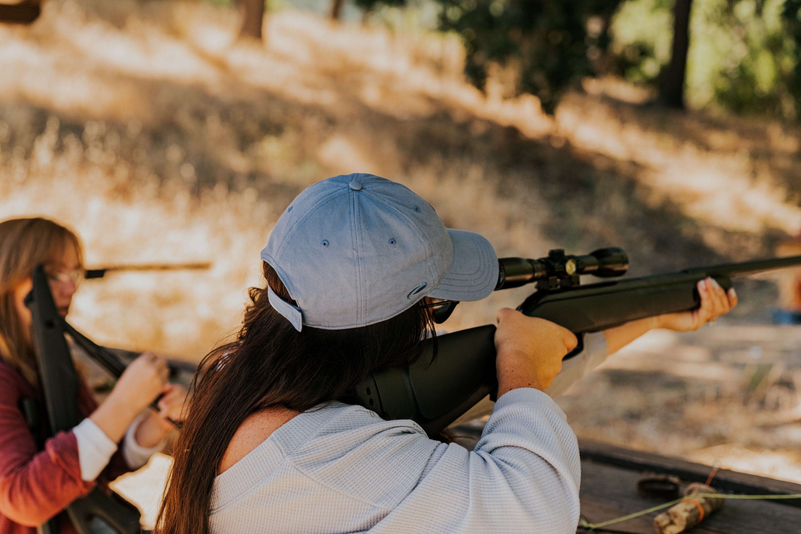 person pointing an air rifle at a target
