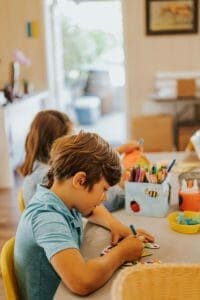 kids sitting at a table doing arts and crafts