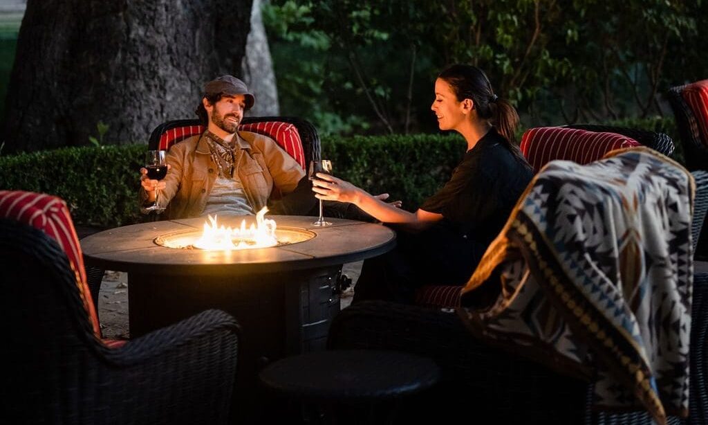 two people sitting outside by a fire