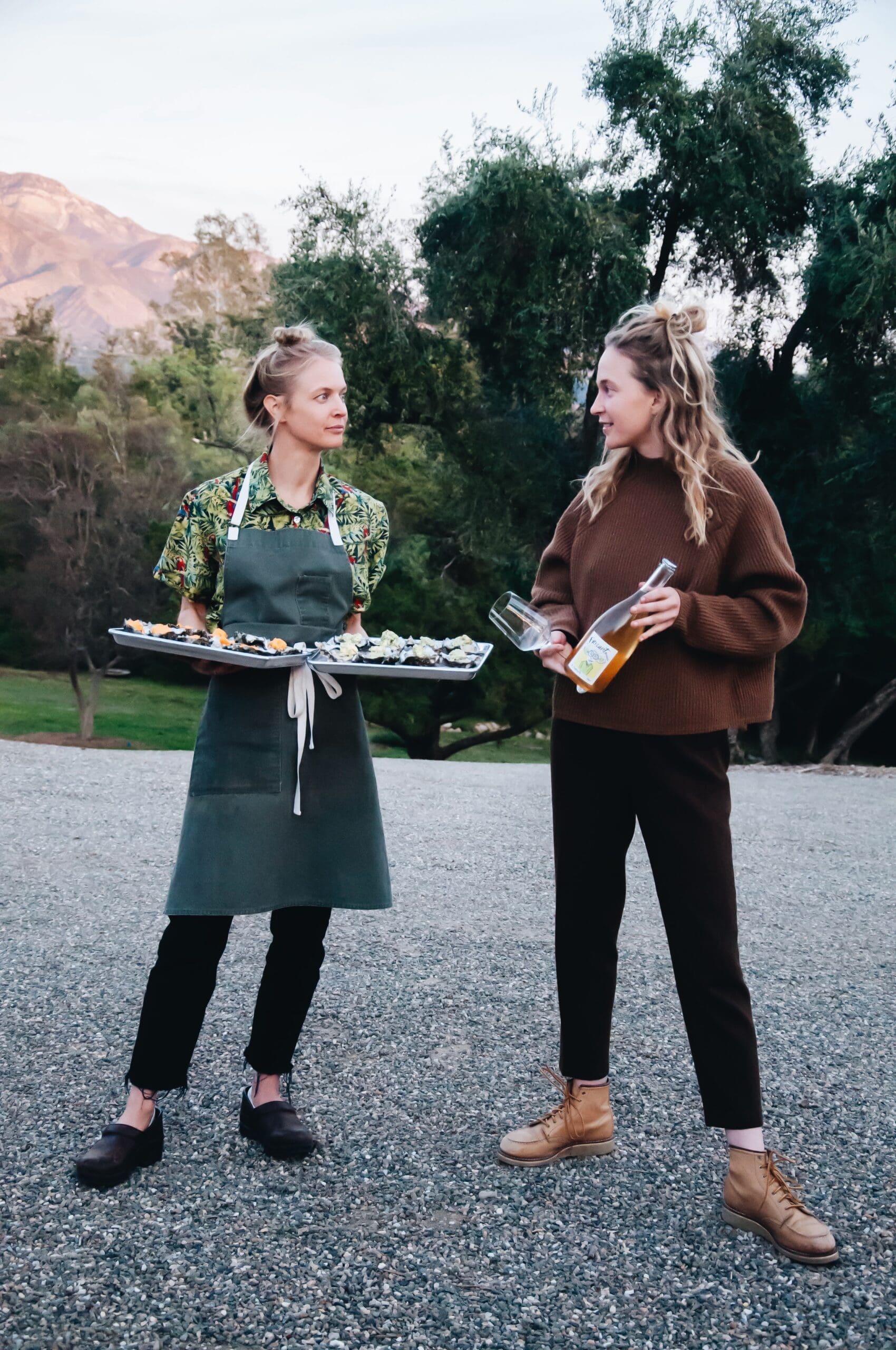 Two girls holding food and drinks